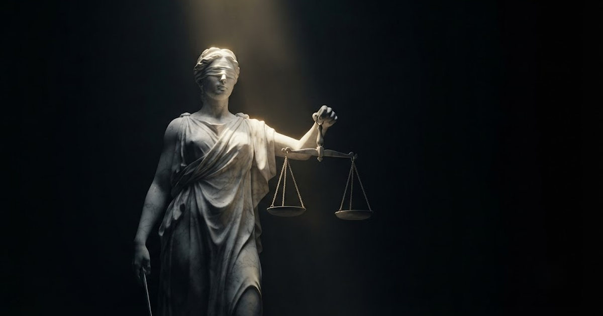 A giant marble statue of Themis holding balanced scales standing calm in darkness under gold light