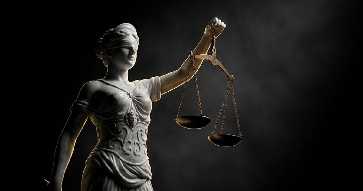A marble statue of Themis holding scales, one pan frozen mid-tilt, lit by hard gold rim light against pure void black.