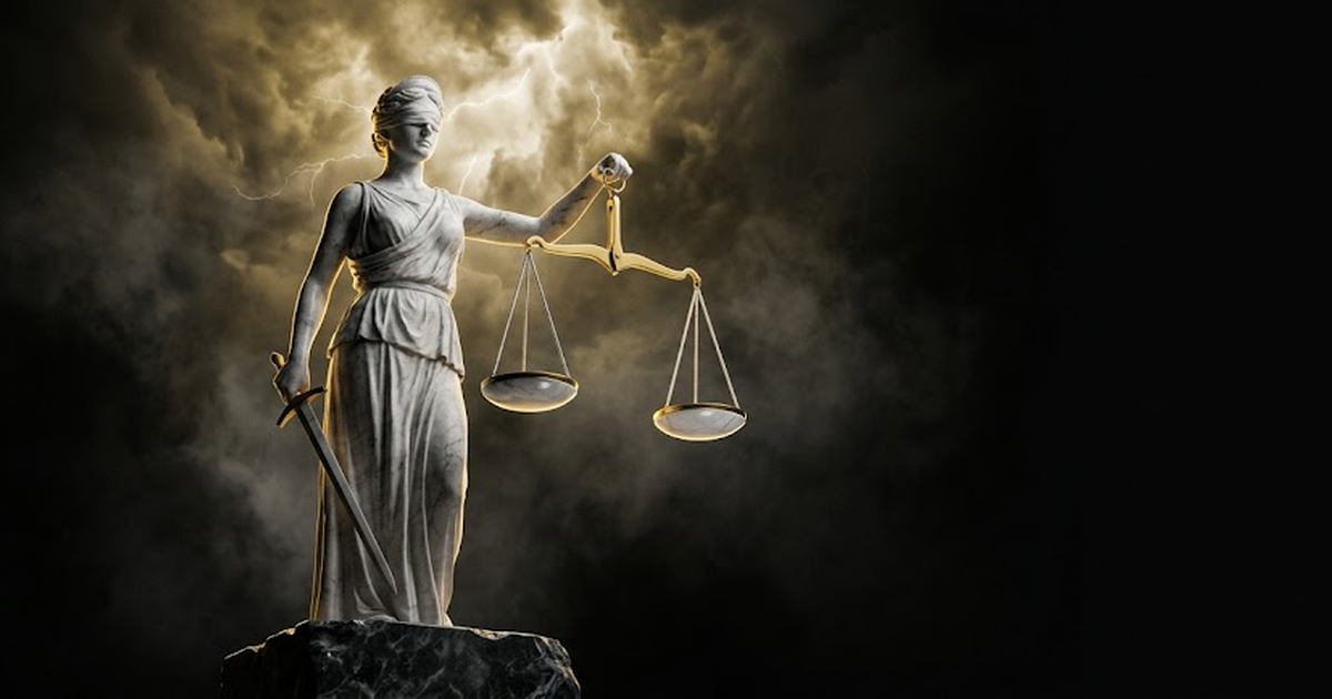 Towering marble figure of Themis holding balanced scales in darkness under gold light